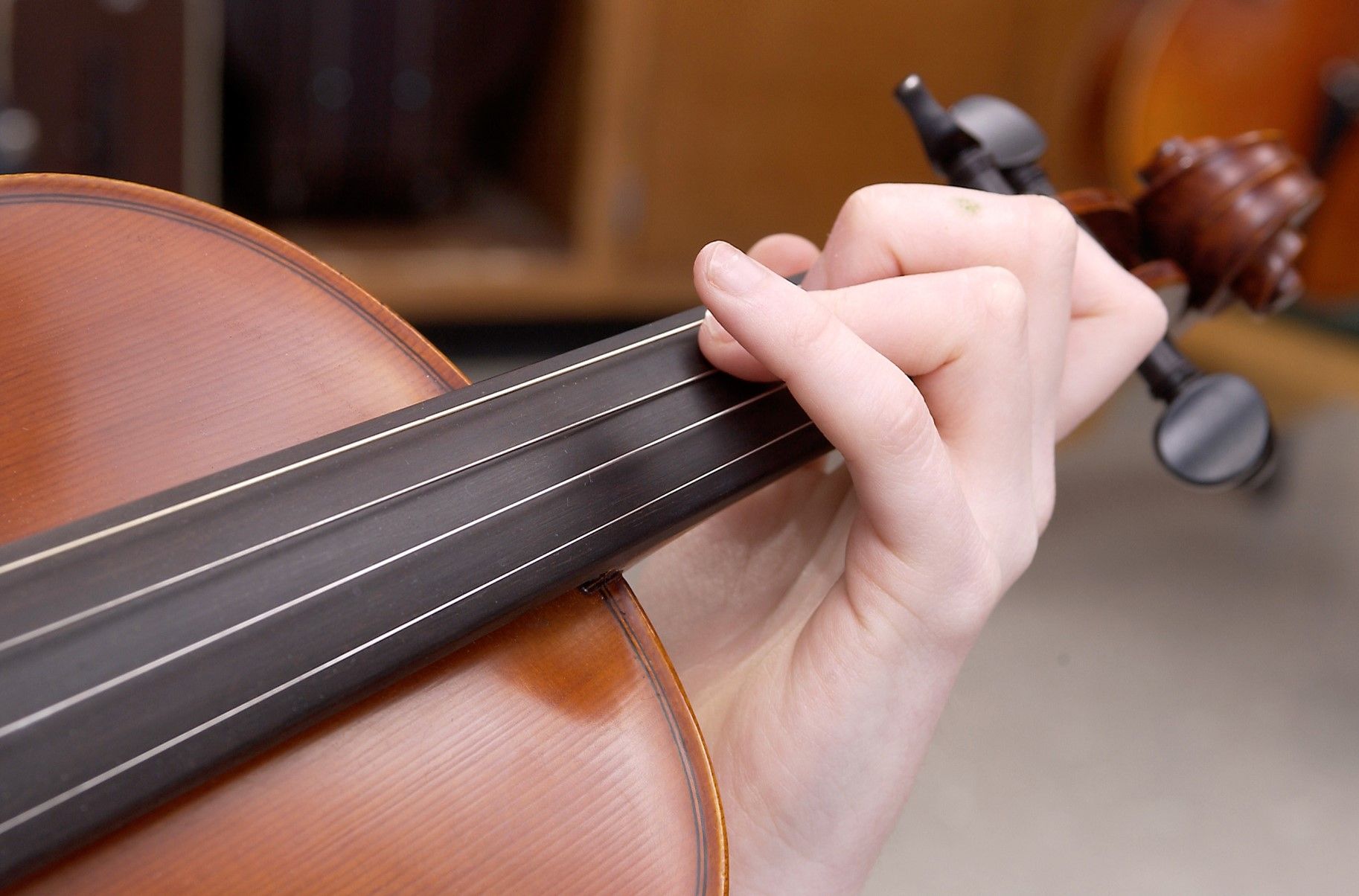 Closeup of someone's hands playing violin.