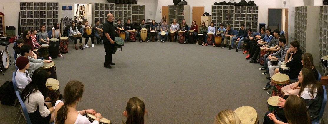 group of music students in a large drum circle 