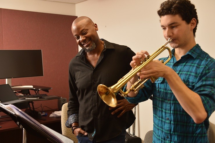 Sean Jones with a male student, who is playing the trumpet