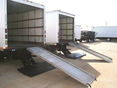 two box trucks with ramps to the open back cab