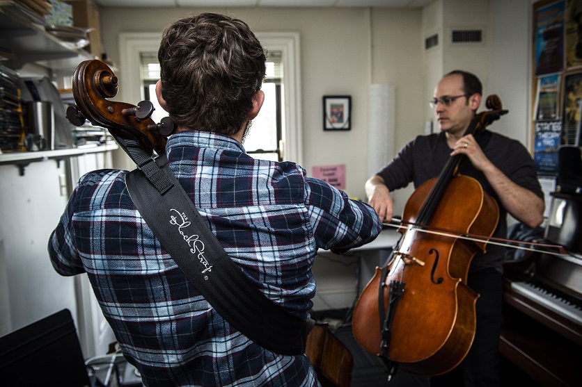 Mike Block with student standing and playing the cello; both are using the Block Strap 