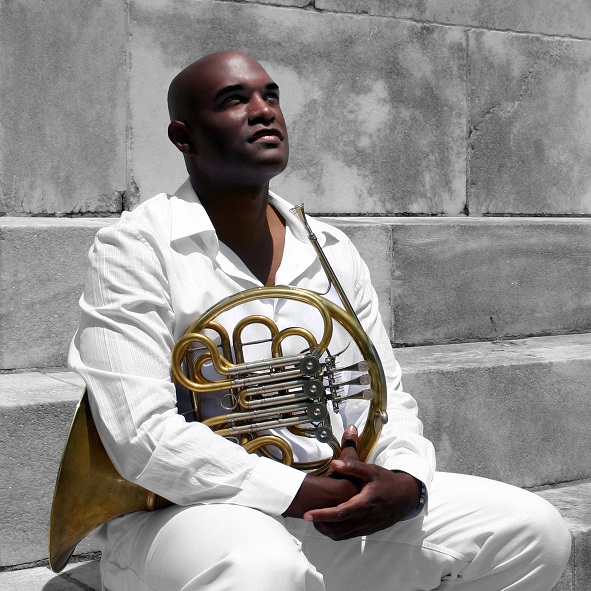 Larry Williams looking up while holding French Horn