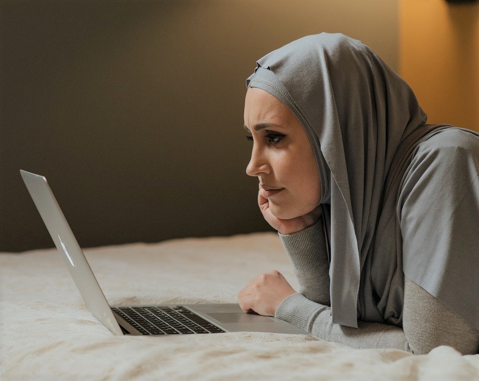 woman staring intently on laptop screen