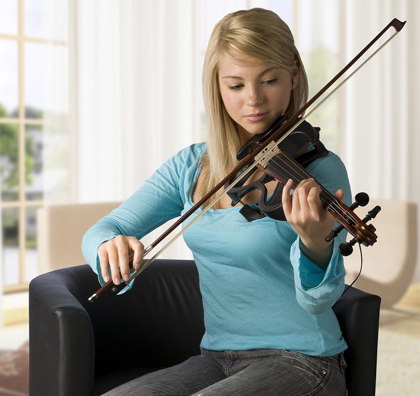 female student playing violin at home