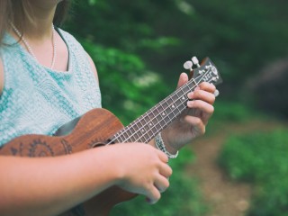 closeup of someone playing he ukulele