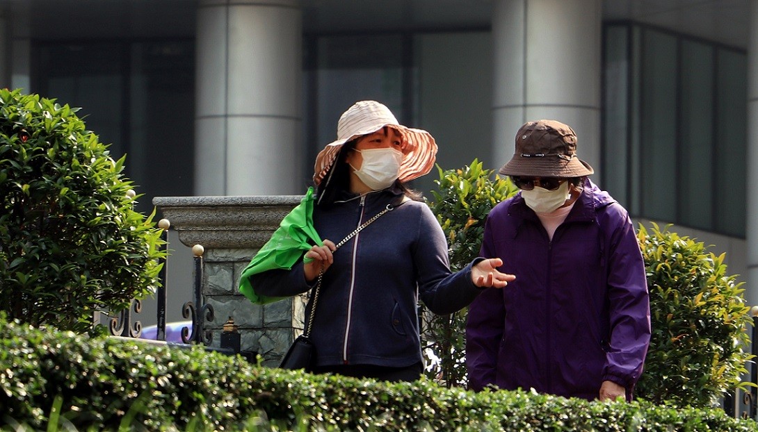 two women wearing masks on a walk
