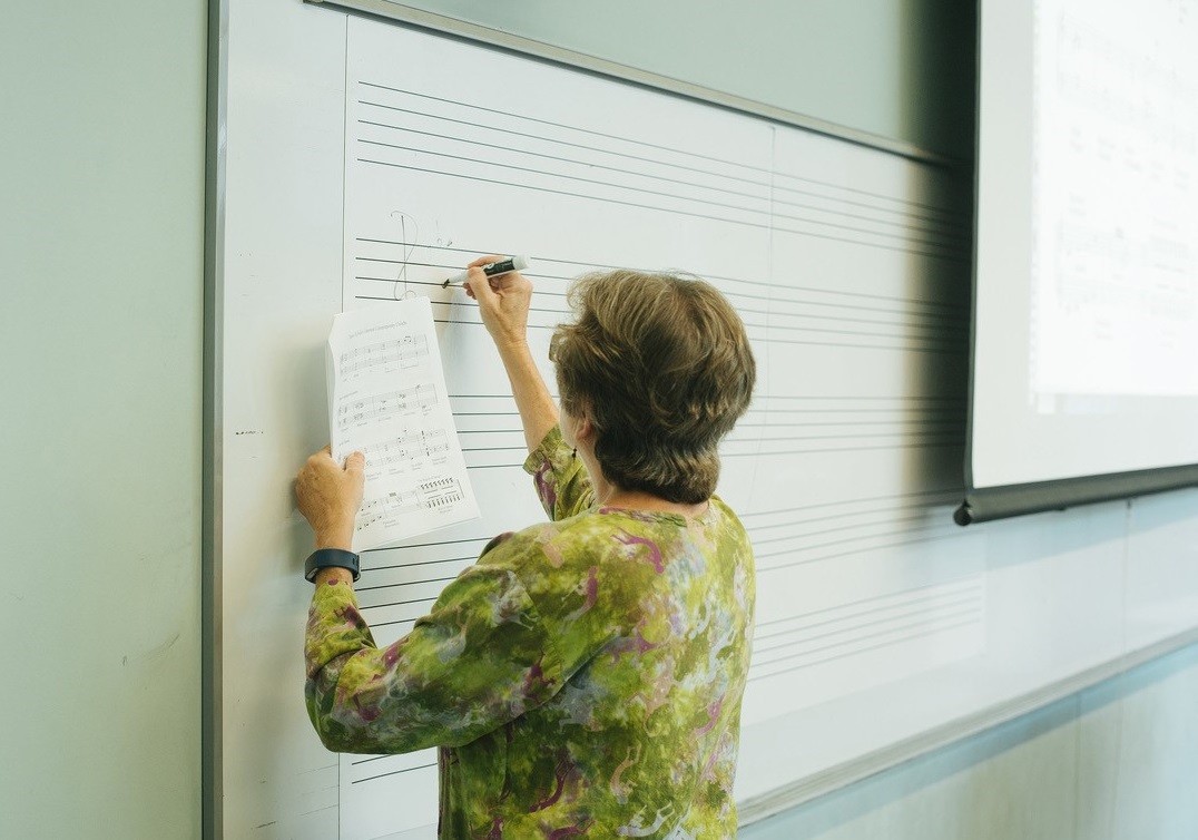 instructor at Young Women Composer Camp writing on white board