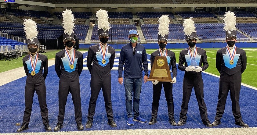 Johnson High School's drum majors and head band director with champion trophy at UIL competition in December 2020