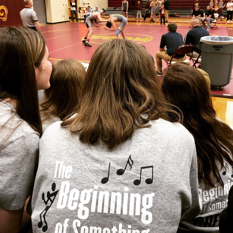 Edgewood Middle School choir members cheering on team members at wrestling match 