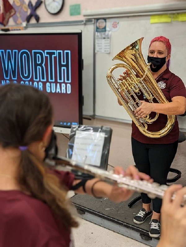 band director Tiffany Cox playing euphonium in front of class