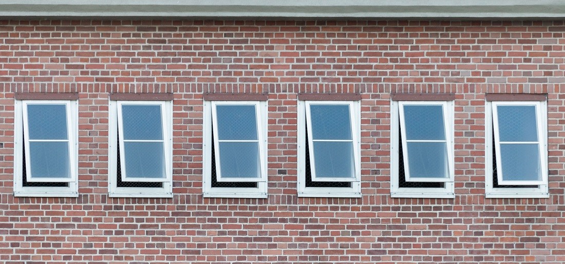 row of open windows in brick building 