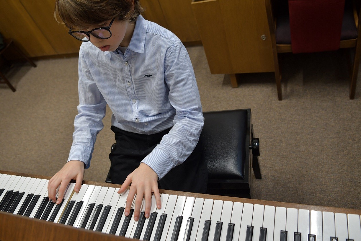 young male student playing piano