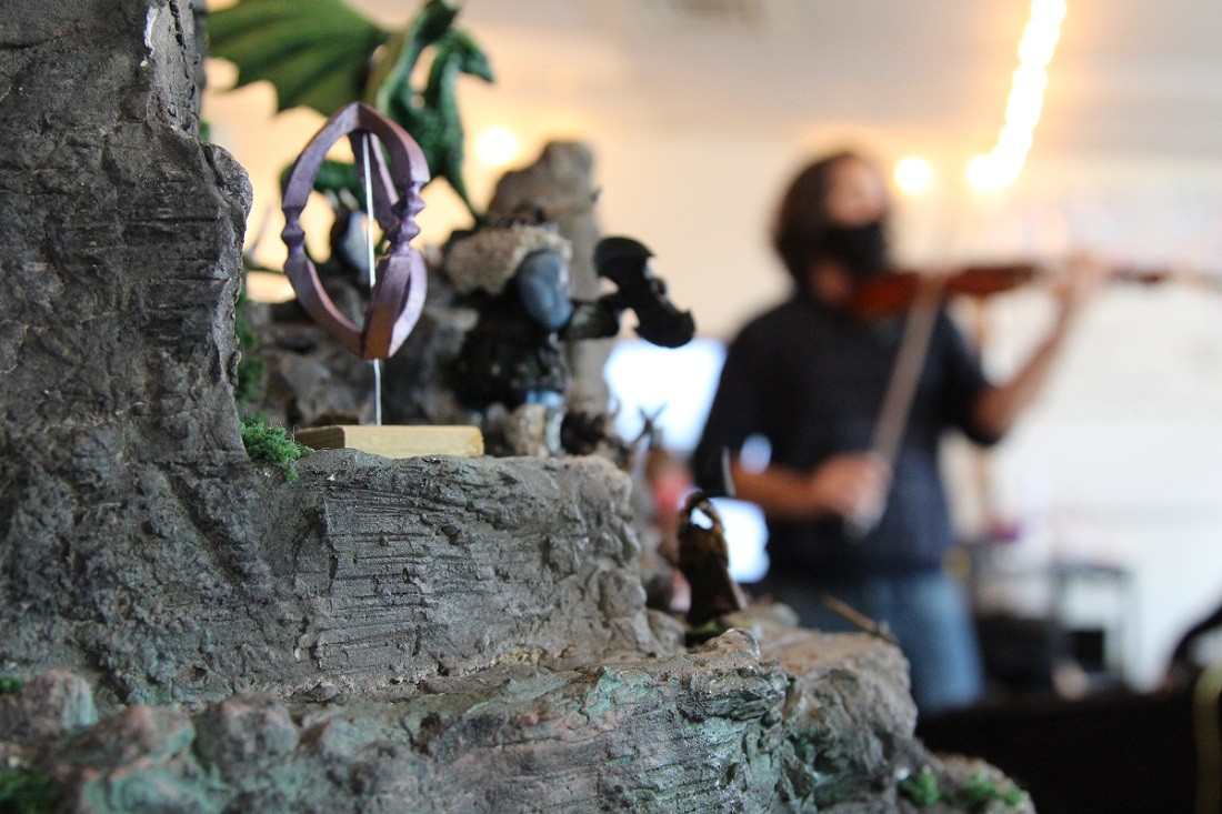 close up of RPG set with Michael Gamon playing violin in the background 