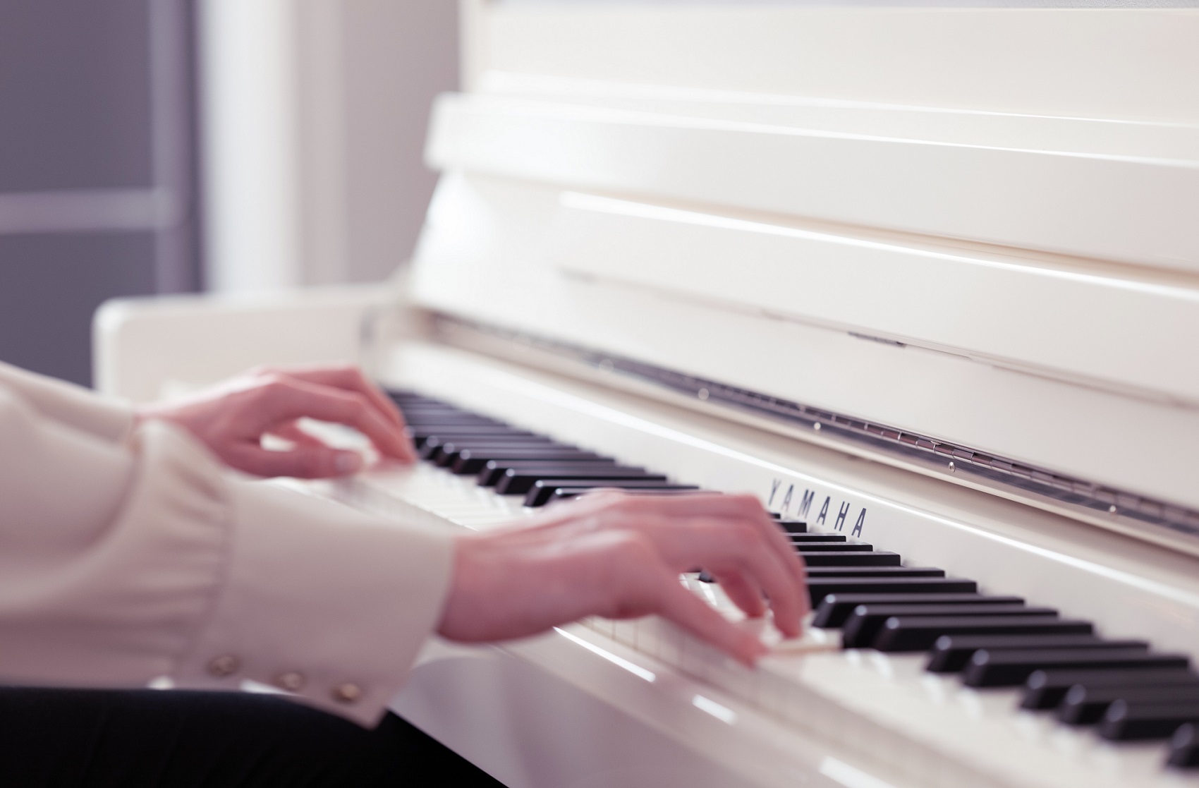 Woman Playing Polished White CLP 700 Upright Piano Close Up