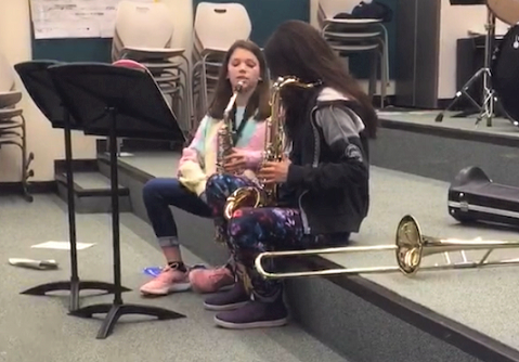 Tricia Lindsey teaches Kendall Booth how to play the saxophone