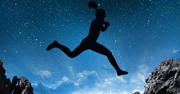 Silhouette of a woman leaping across a starlit sky.
