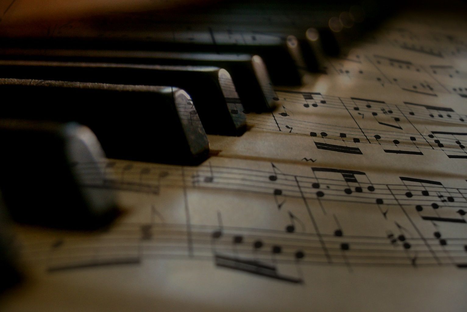 piano keys with sheet music overlaid on keys