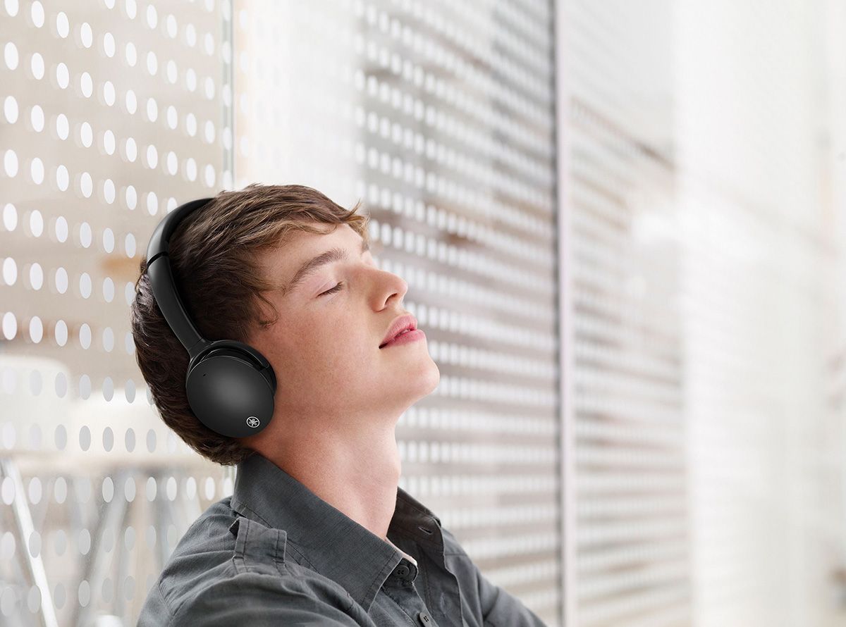 Young man with his eyes closed and wearing headphones.