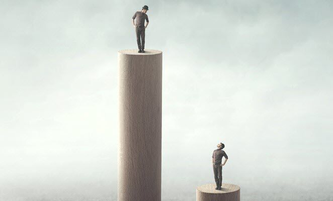 Shows someone standing on a tall pedestal with hands on hips looking down at someone on lower pedestal looking up.