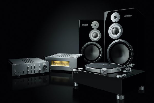 Various Yamaha products including an amplifier, preamplifier, two speakers and turn table set on black background.