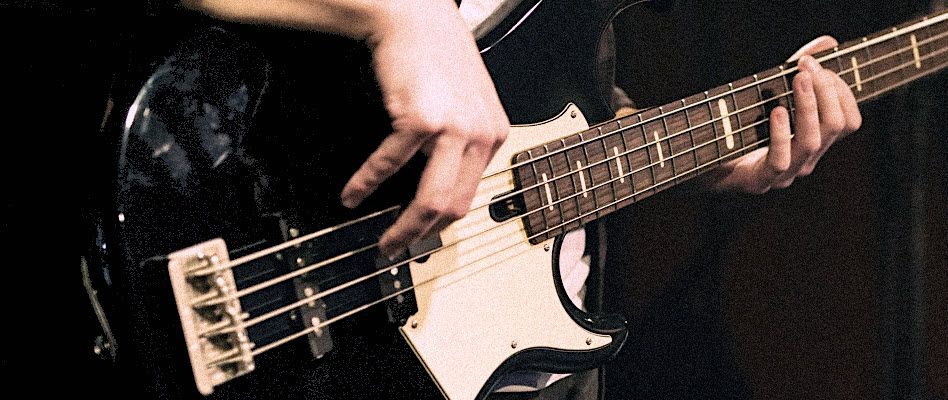 Closeup of hands playing an electric guitar.