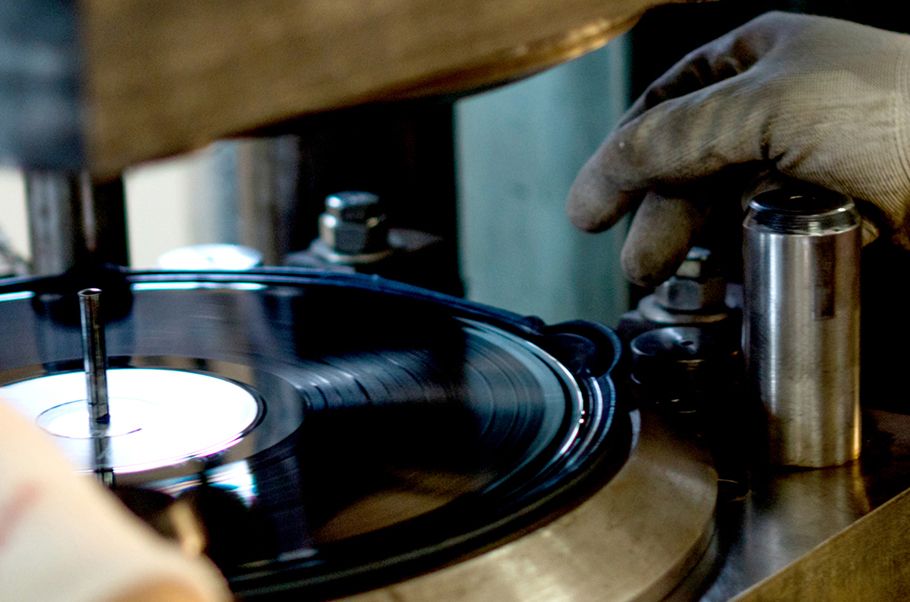 Closeup of a vinyl record being pressed.