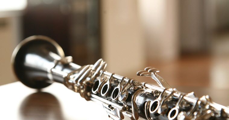 Clarinet laying on a table with sunlight coming through window in background.