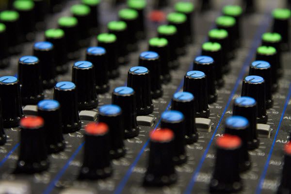 Rows of knobs on a sound mixing board.