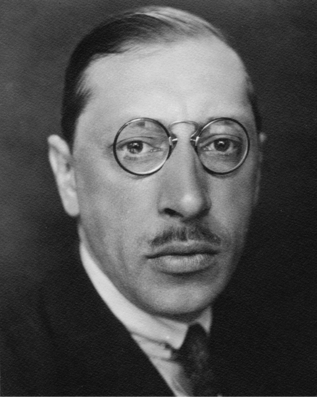 An image of Igor Stravinsky, a man with a melancholic expression and round glasses.