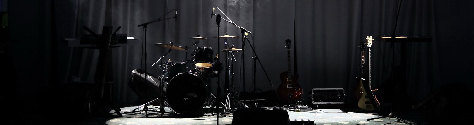 An image of a stage with musical instruments and mics set up on it.