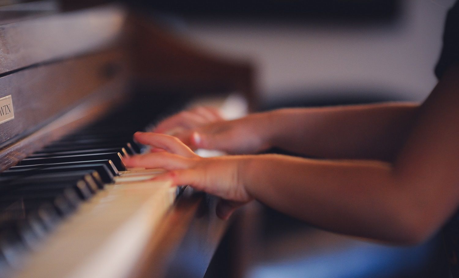 close up of child's hands playing the piano