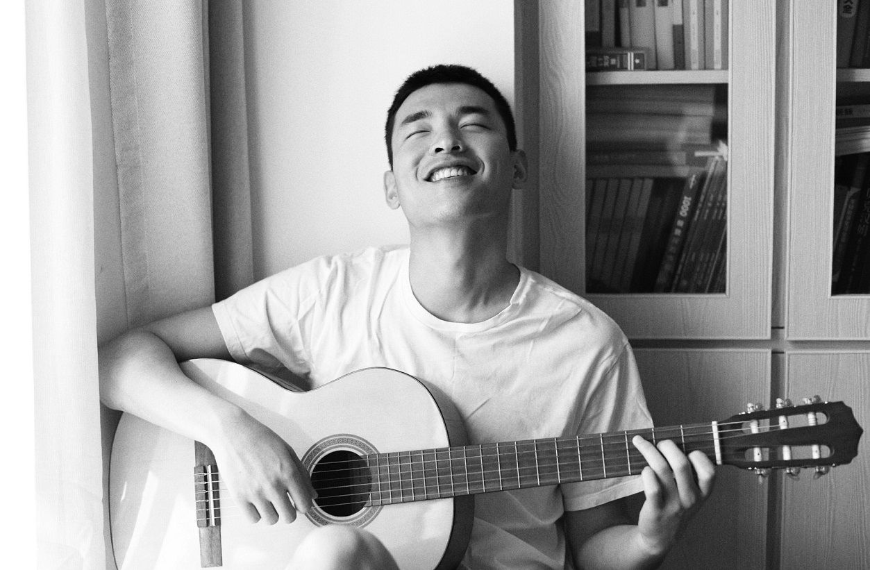black-and-white photo of student playing the guitar