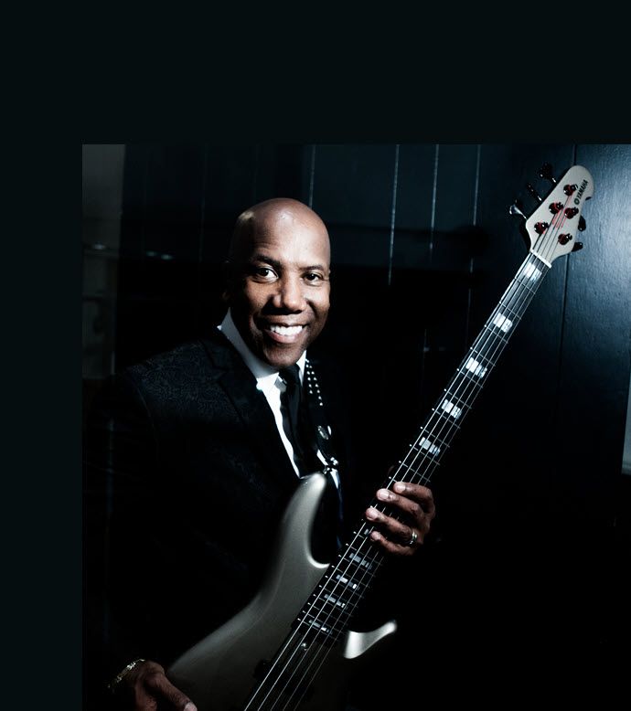 Professional shot of smiling man in suit holding electric guitar.