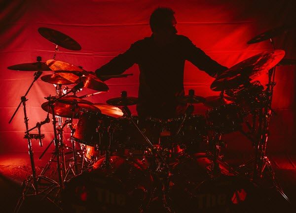 Drummer in silhouette playing the drums.