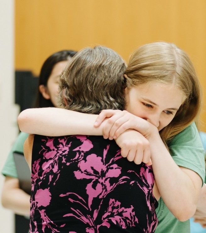 female student embracing teacher