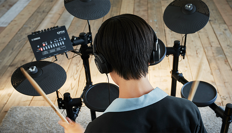 Young man playing electronic drum set.