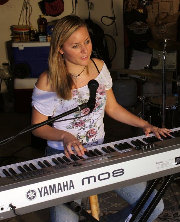 Young woman at home playing a Yamaha synthesizer.