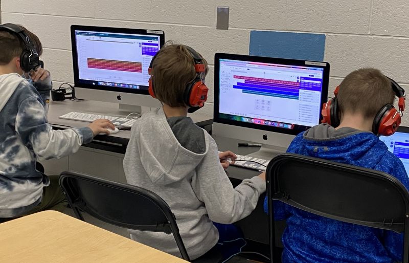 three students working at DAWs
