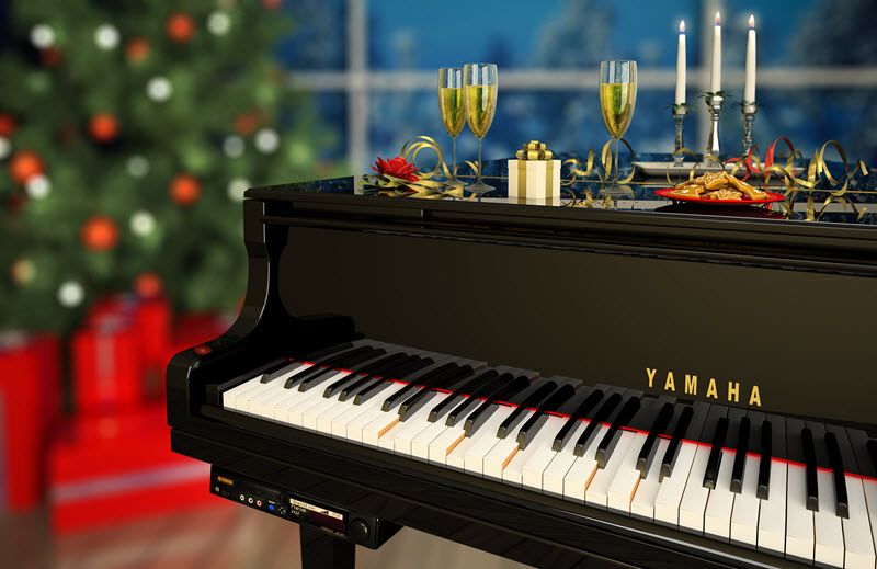 Yamaha grand piano in a living room setting decorated for holidays, with Christmas tree and candles.