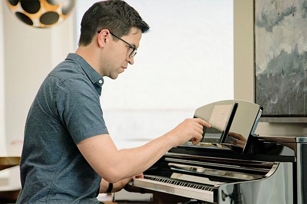 Man sits at keyboard with tablet device.