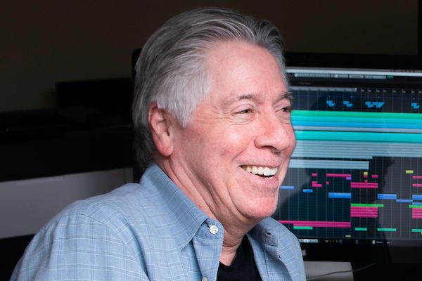 Alan Silvestri smiling in studio in front of monitors.