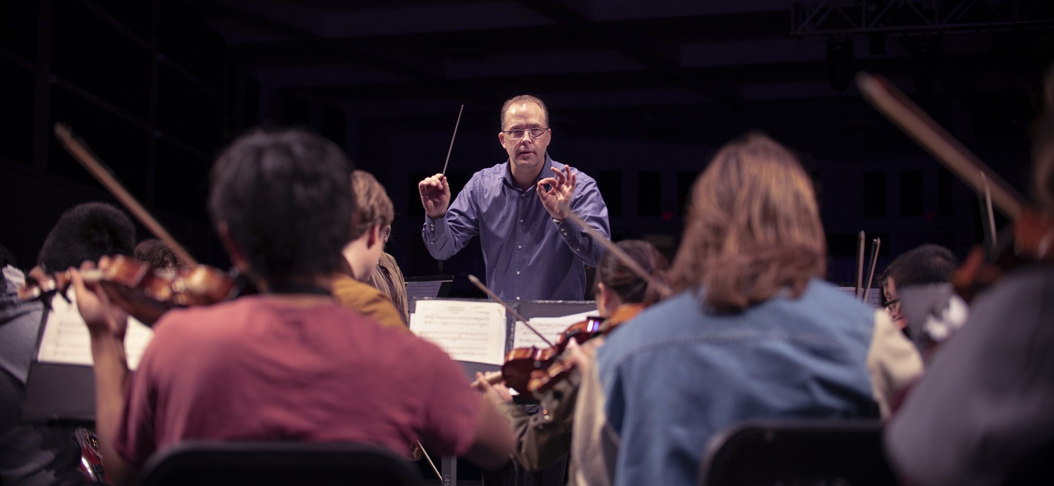 male band director conducting orchestra