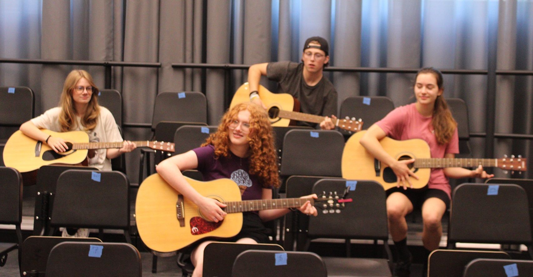 four guitar students in class