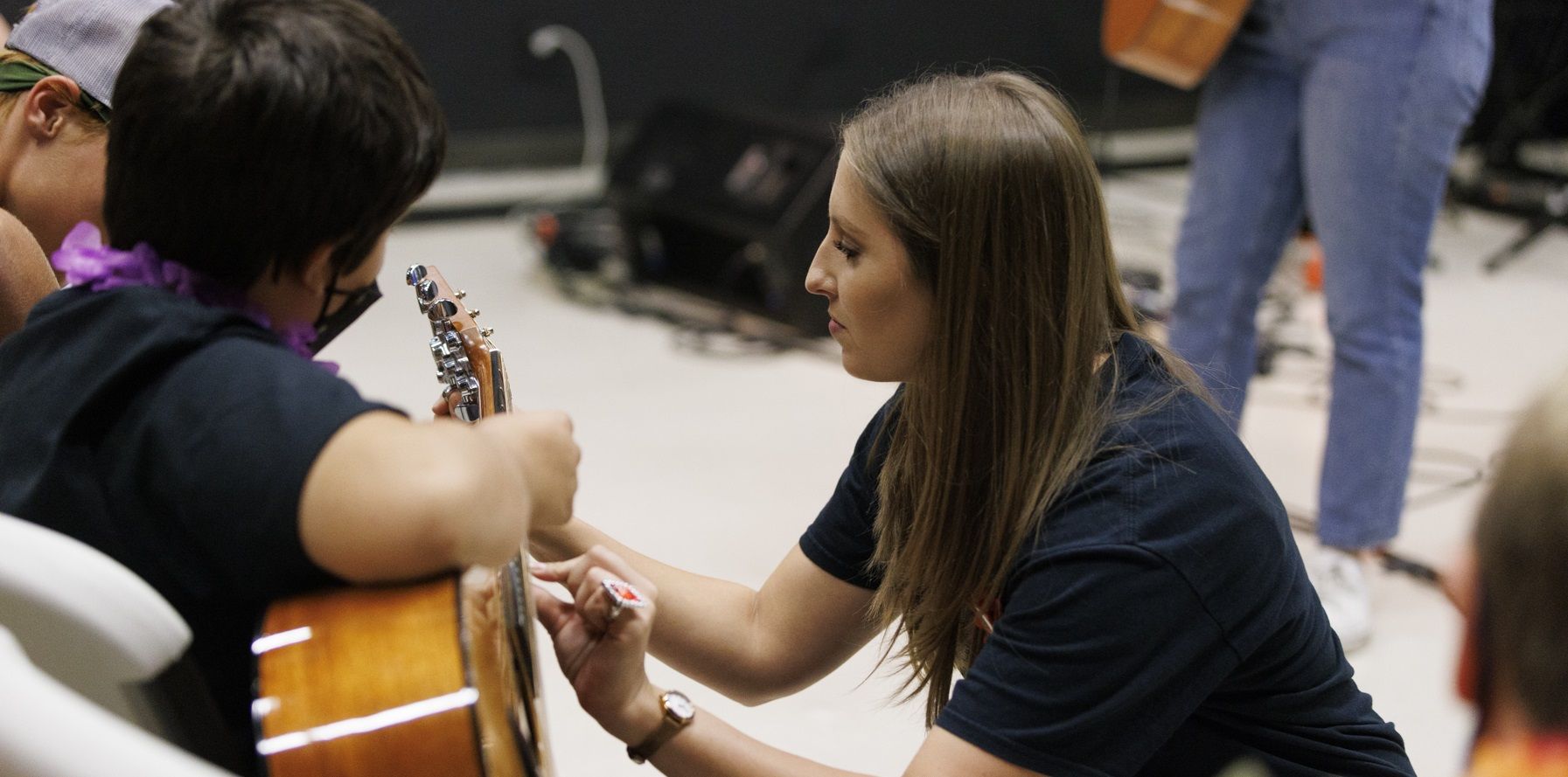 music teacher helping student with guitar