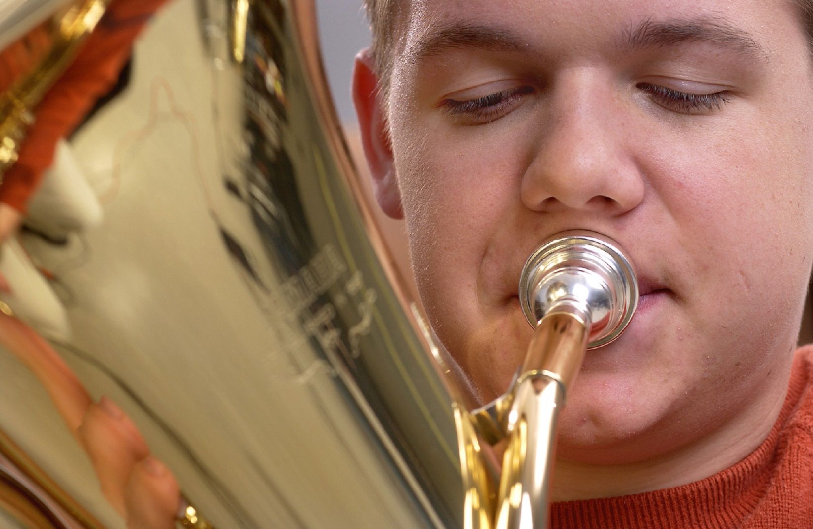 close-up of male student playing tuba