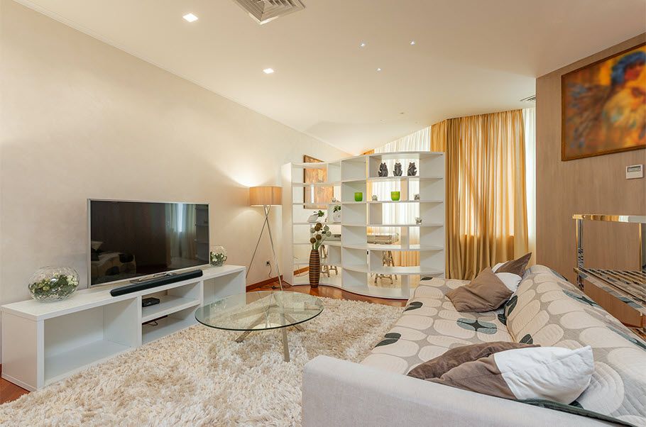 Modern living room with large flat screen tv on wall.