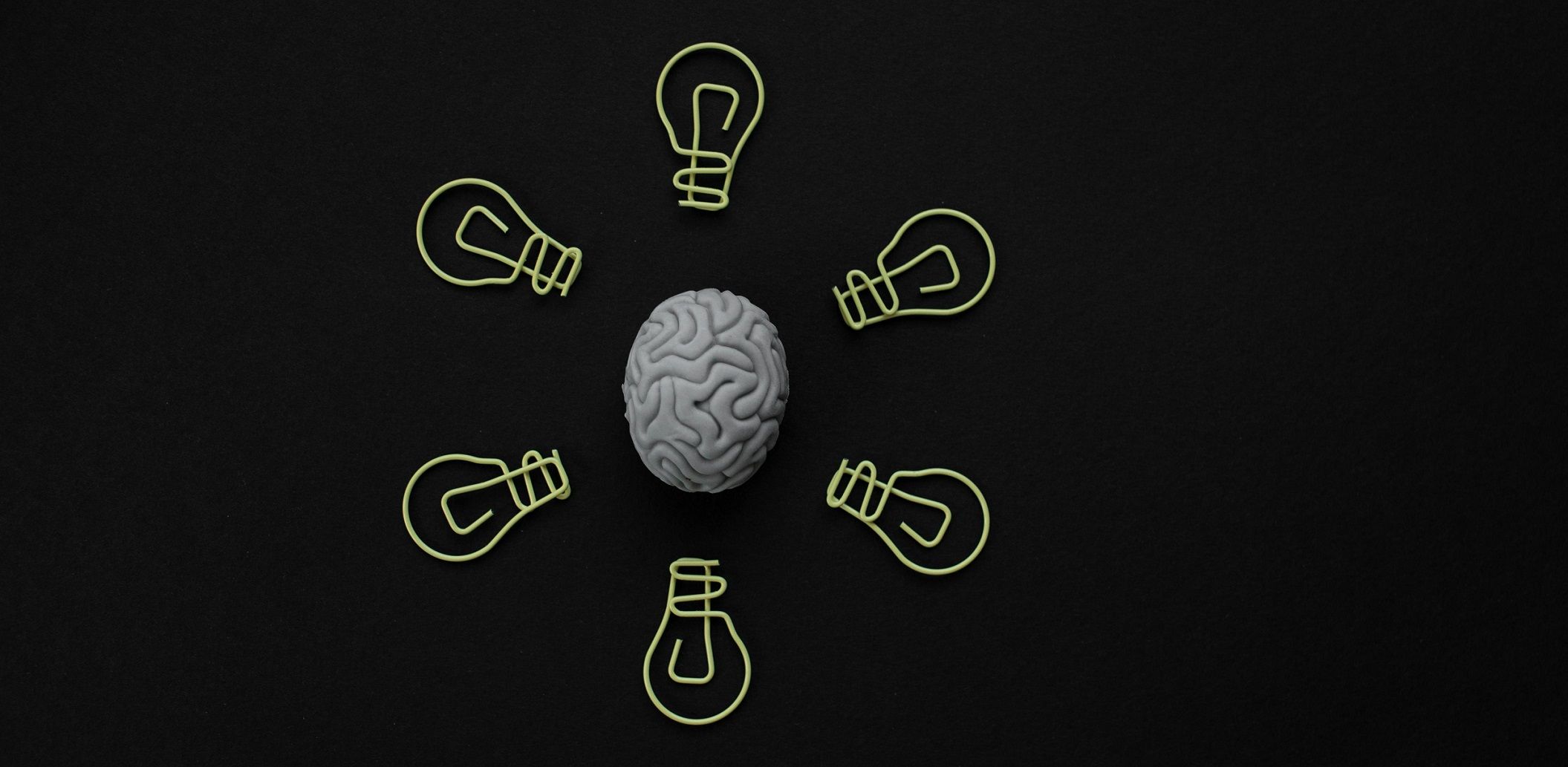 artwork of brain surrounded by six lightbulbs