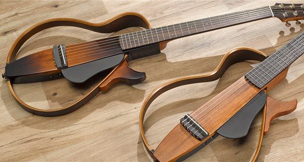 Two electric guitars with open bodies laying on a table.