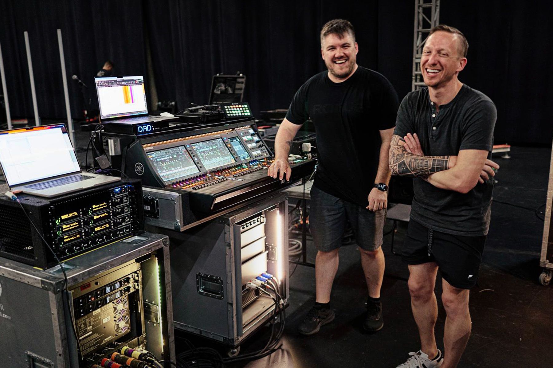 two men standing in front of audio mixer