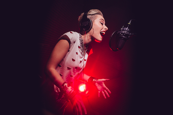 Woman singing joyously in studio.